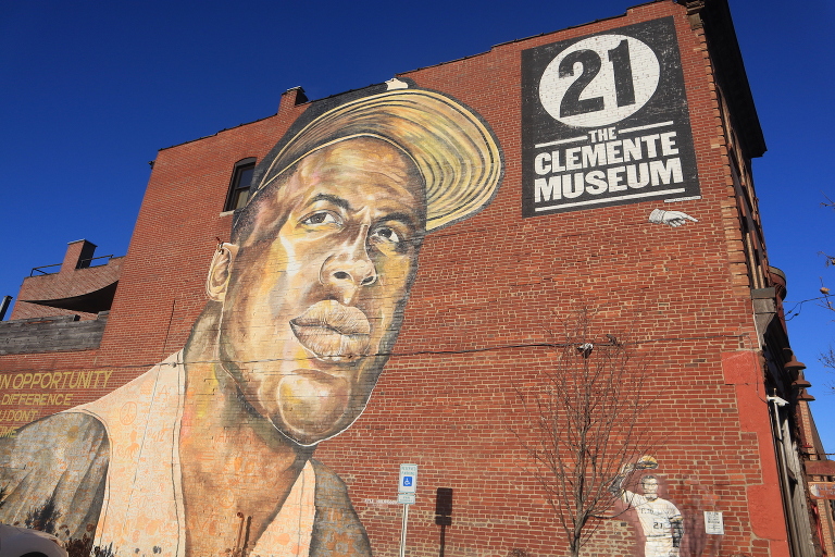 Outside of the Roberto Clemente Museum in Pittsburgh. Has a mural of Roberto Clemente on the brick wall