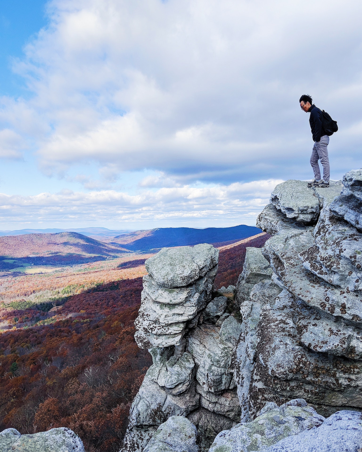 person standing on a rock overlooking the mountains in the distance 